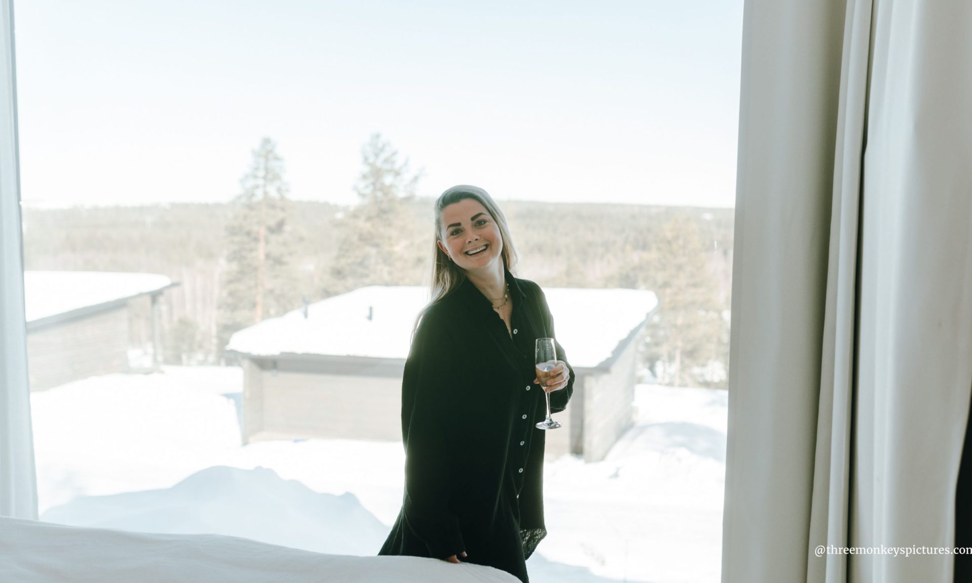 A woman smiling happily at suite in front of a arctic view