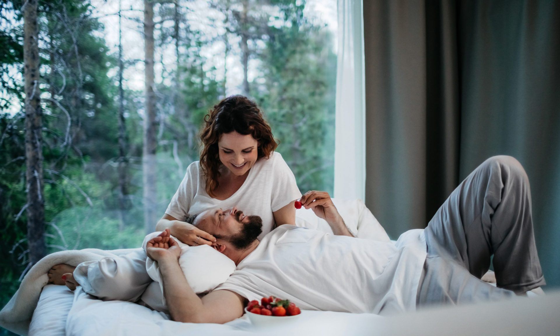 Couple enjopying a romantic midnight sun at Arctic TreeHouse Hotel suite