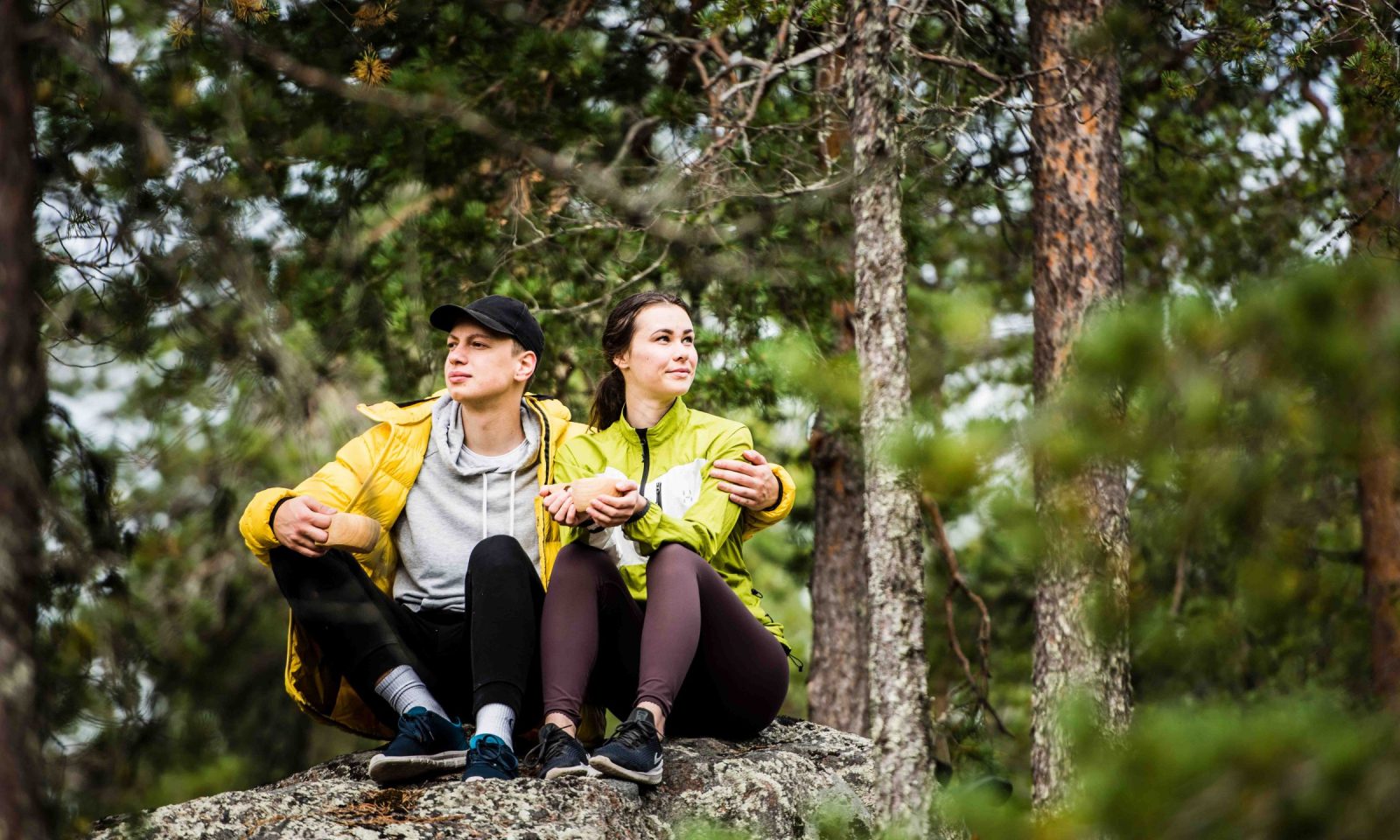 A couple having a break in northern forest during the hike.