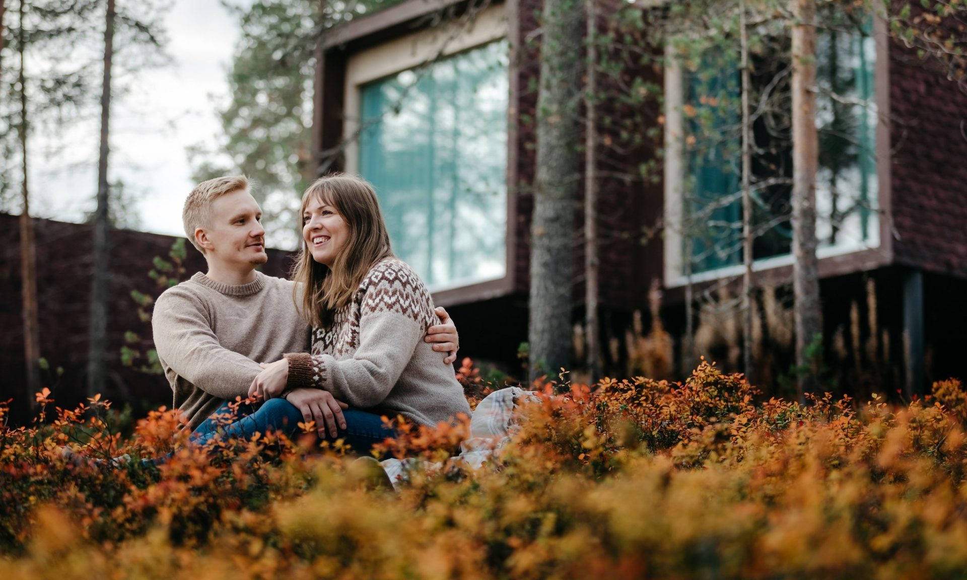 Couple enjoying autumn in front of Arctic TreeHouse Hotel suites.