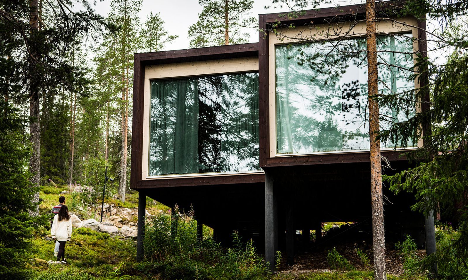 Mies ja nainen kävelevät sviittiin Arctic TreeHouse -hotellissa Lapissa, Rovaniemellä.