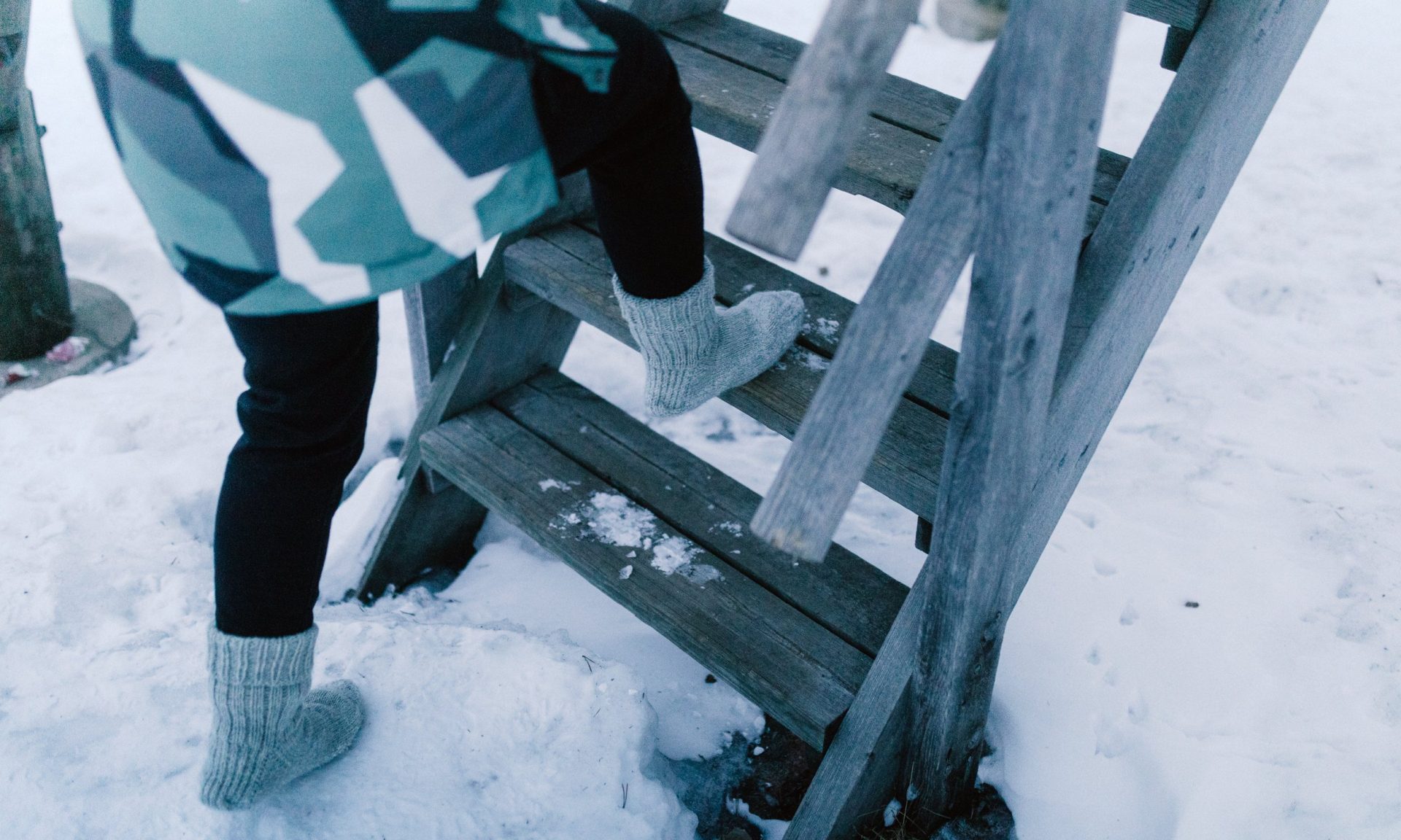 Wool sock nature walk in snowy forest of Lapland.